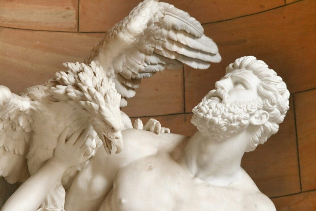 A marble statue close up of Prometheus being attacked by an eagle sitting on his shoulder