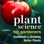 Ripe tomatoes on the vine with the book "Plant Science for Gardeners" in view.