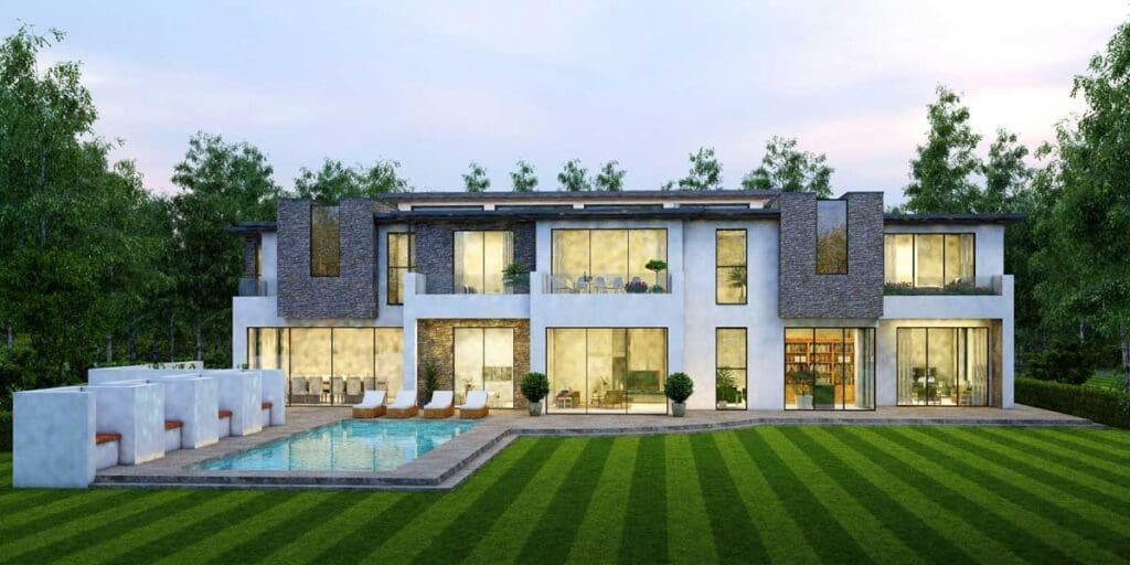 A beautiful modern 2-story home full of lit windows nestled on a landscaped property with a pool.