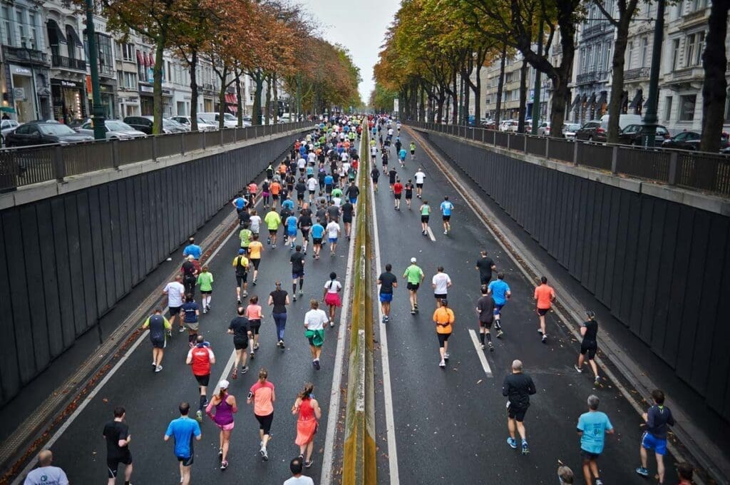 A large group of people run down both sides of a city street.