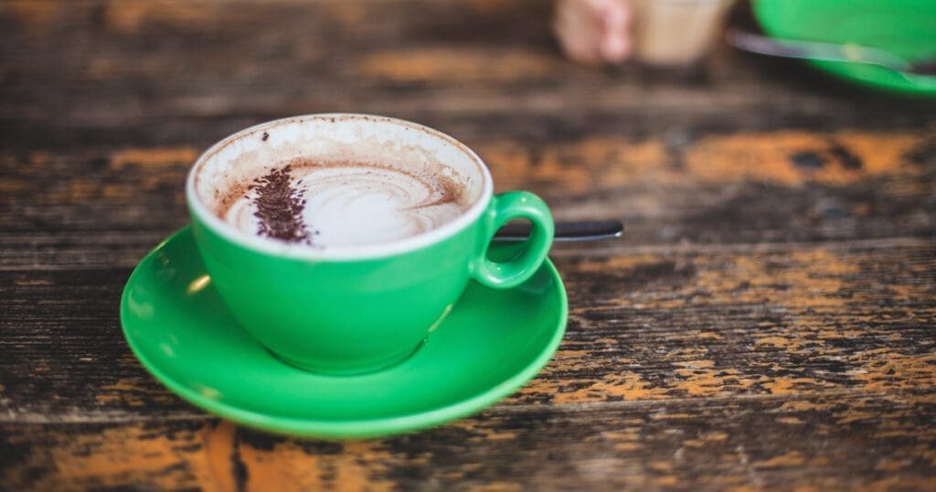 A delicious-looking cup of hot chocolate with foam and chocolate sprinkles.