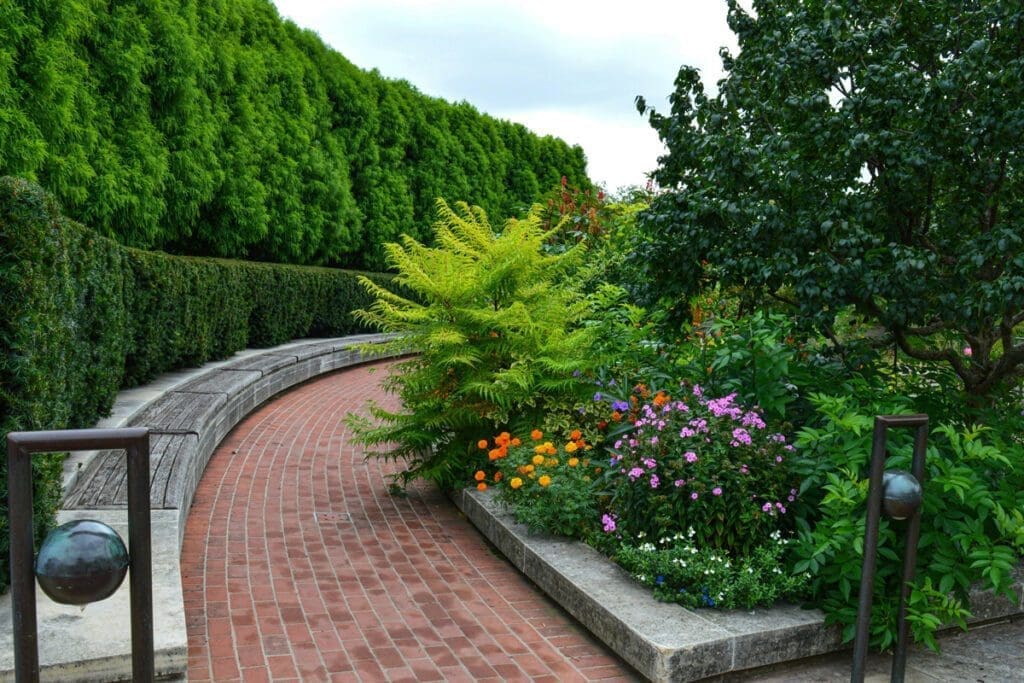 Manicured lush colorful garden with benches, hedges, flowers and bushes