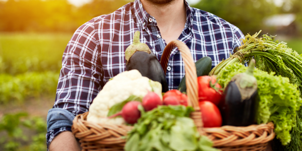 Farmer holding a basket of vibrant organic food in a flourishing garden.