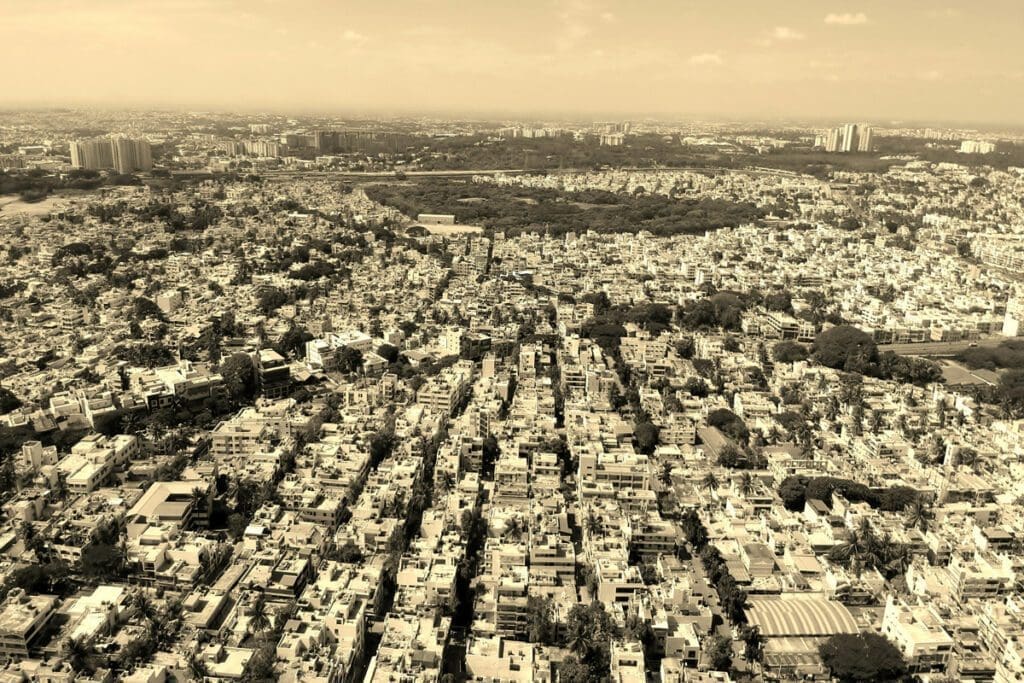 Aerial view of a sprawling cityscape with numerous buildings under a cloudy sky, reflecting the intricate food system that sustains our bustling urban life on this healthy planet.