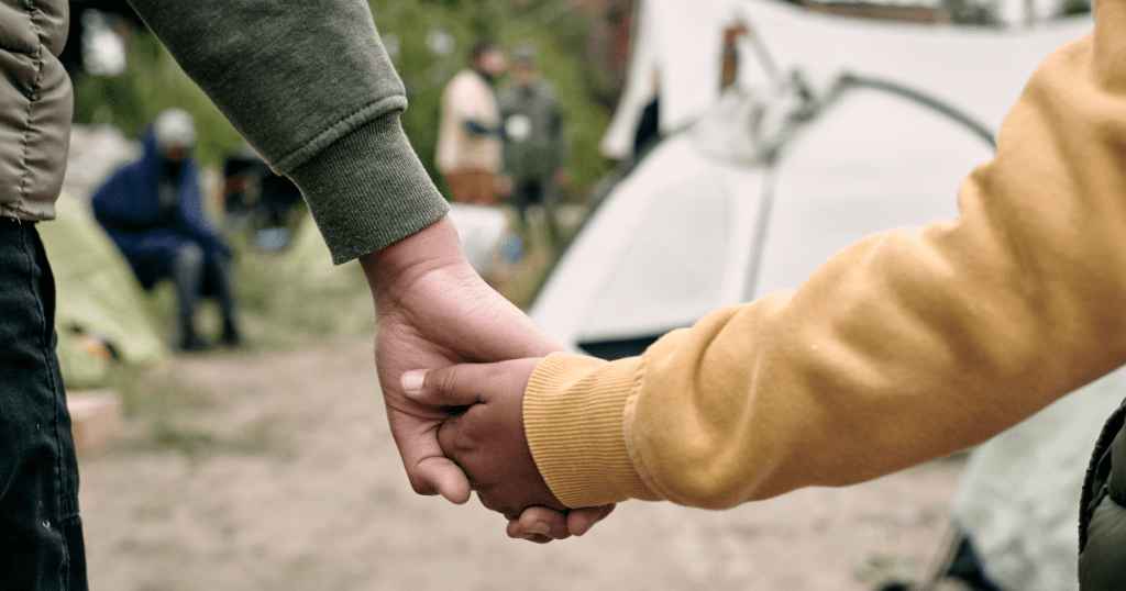 Two people holding hands, showcasing true connection in front of a tent.