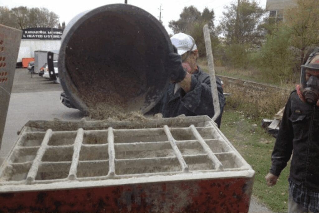 Pouring Hempcrete mixture into a machine hopper—ideal for eco-friendly construction projects.