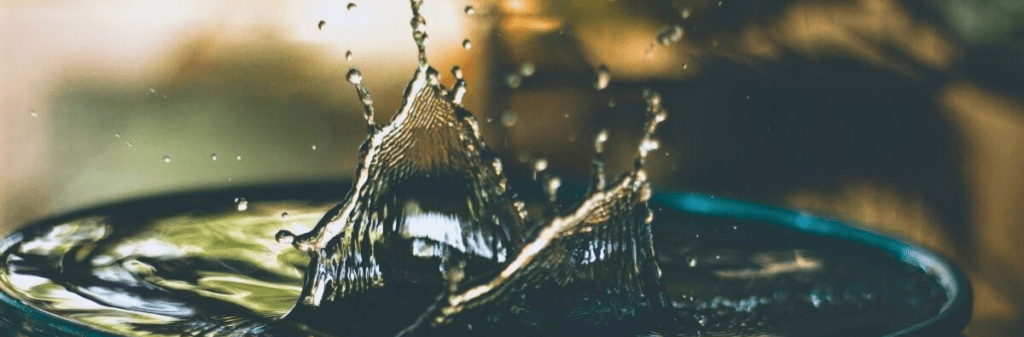 Water splashes upward like a crown, evoking the beauty of rainwater harvesting in motion.