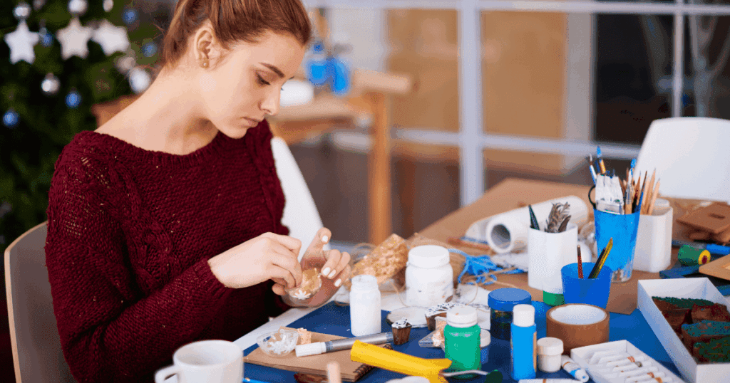 Woman crafting at a table, focused on her project—youth leadership in a distracted world.