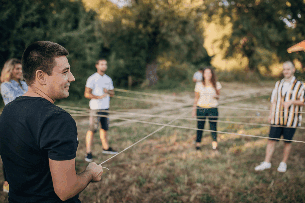 Young leaders join hands outdoors, helping youth thrive in a connected circle.
