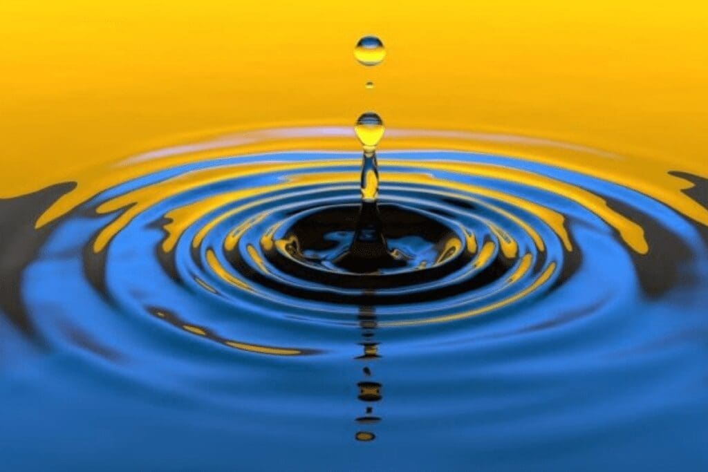 A water droplet sparks ripples in blue water, inspiring awareness for a better world.